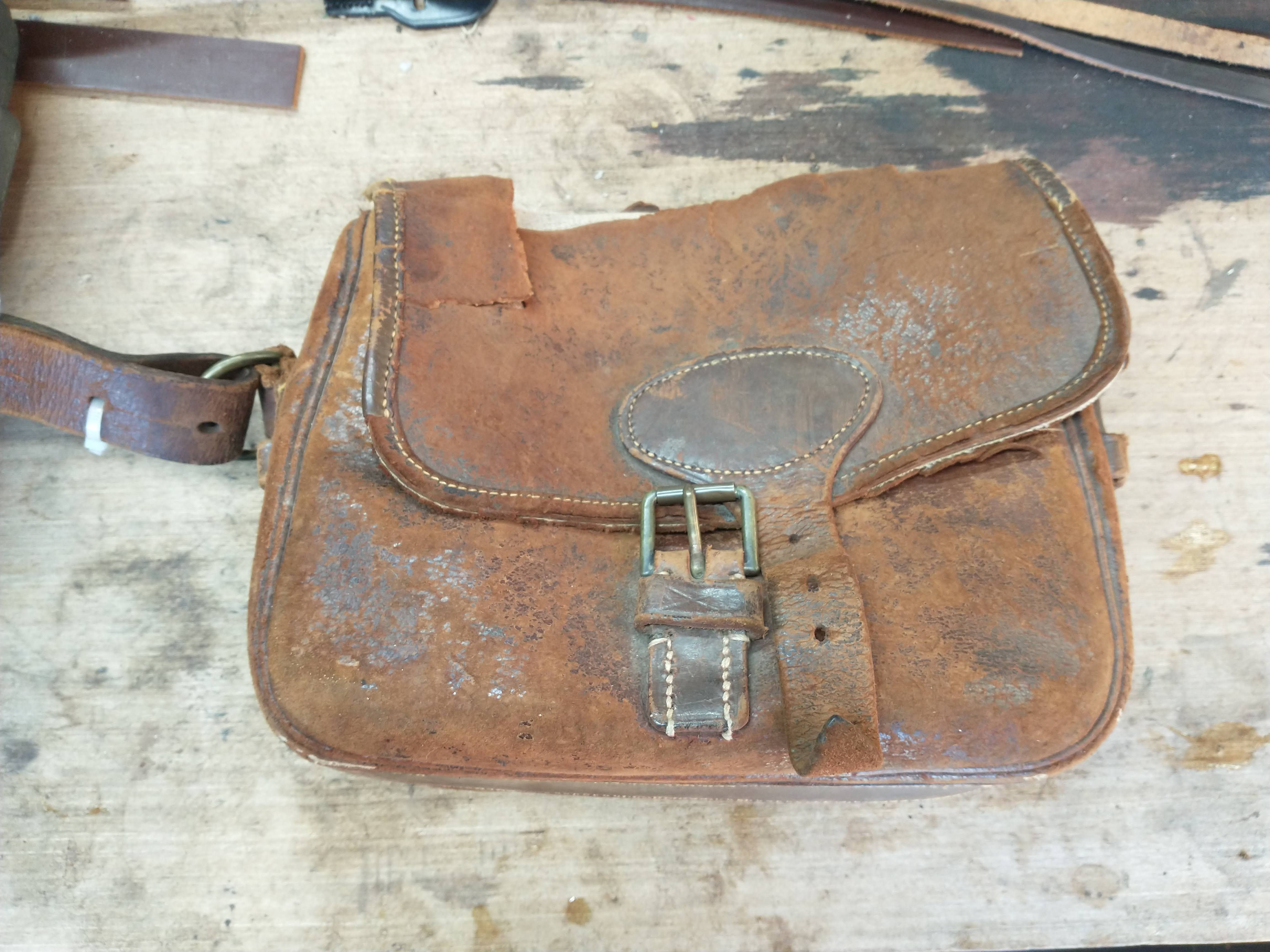 An old leather cartridge bag with a badly damaged flap and extremely dry leather